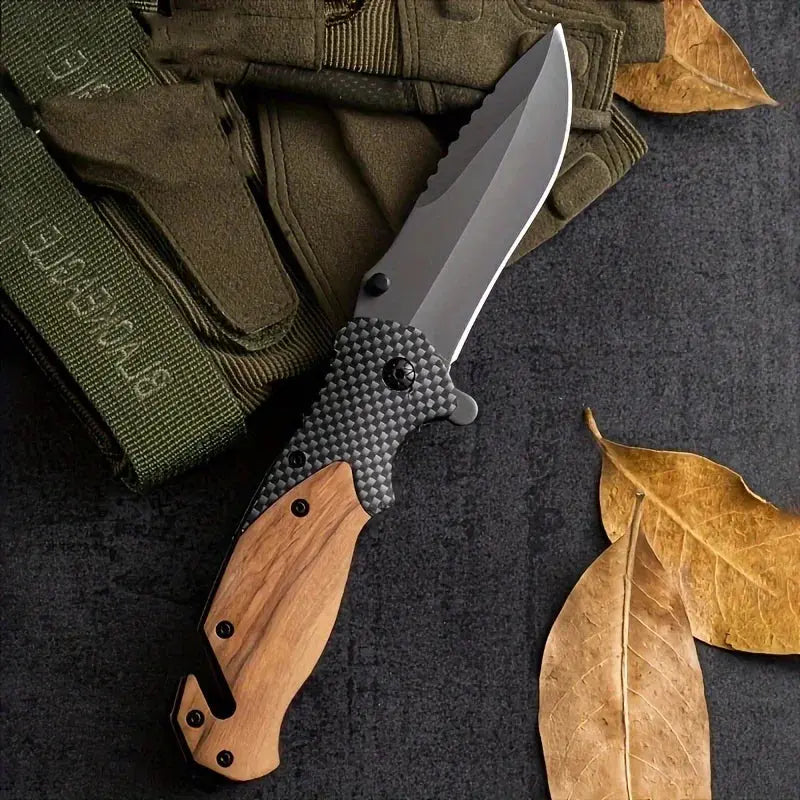 Folding knife with a partially serrated stainless steel blade, wooden and carbon fiber-patterned handle, placed against a bundle of black braided rope.